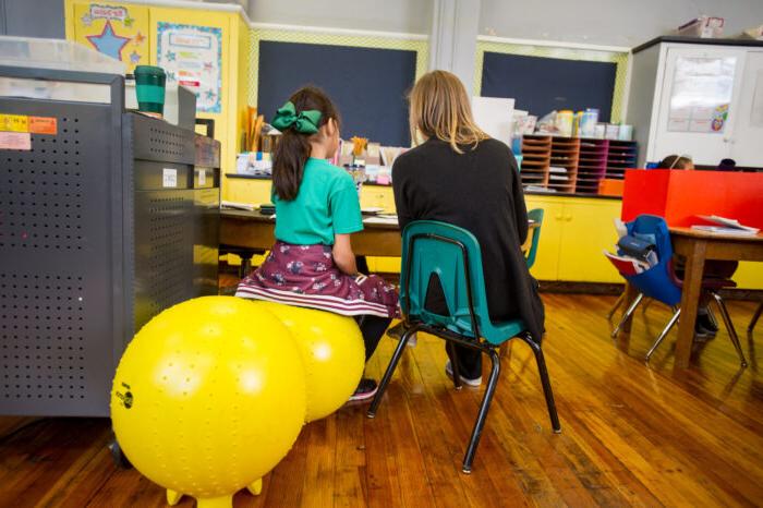 Teacher in a classroom with a young student.